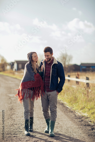 Young couple walking on a dirt path in the countryside