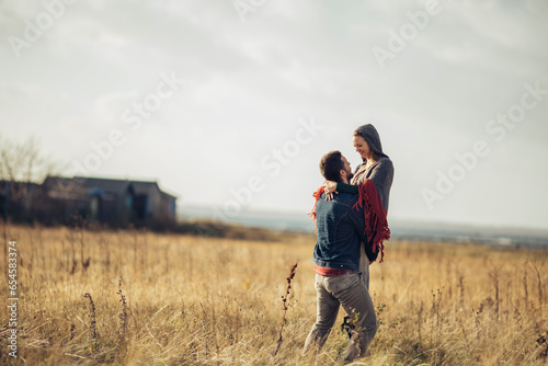 Young couple having a stroll on a grassland in the countryside