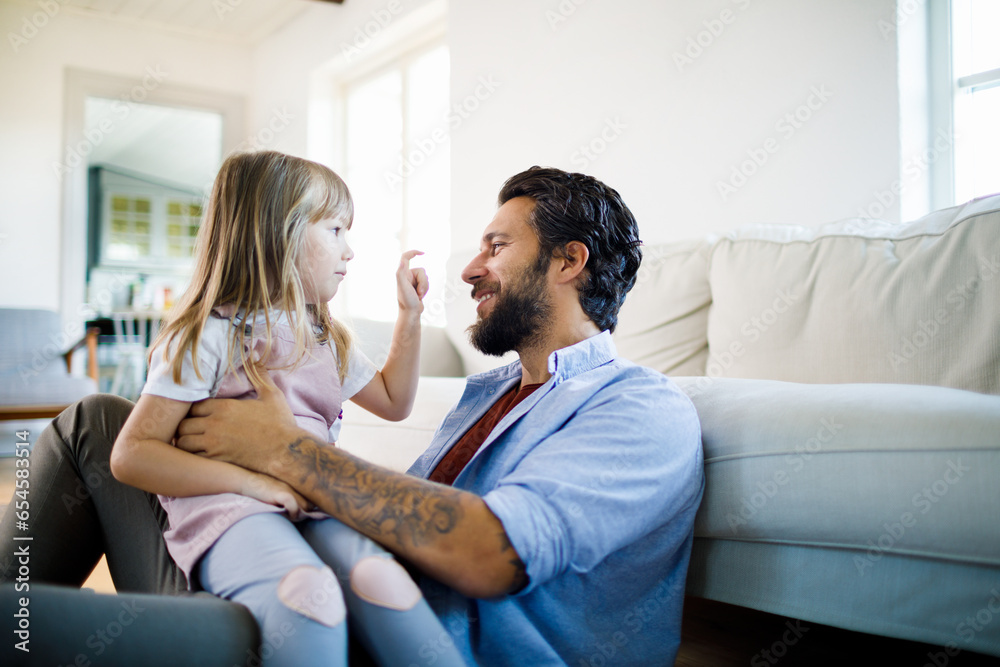 Young father playing and having fun with his daughter in the living room at home Young father playing and having fun with his daughter in the living room at home