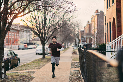 Young man jogging beside a road in the city © Geber86