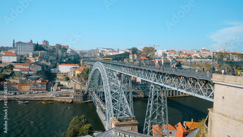 Beautiful view of city with bridge and metro. Action. Landscape of summer city with bridge over river and surface subway. Metro train is moving on beautiful bridge on sunny summer day