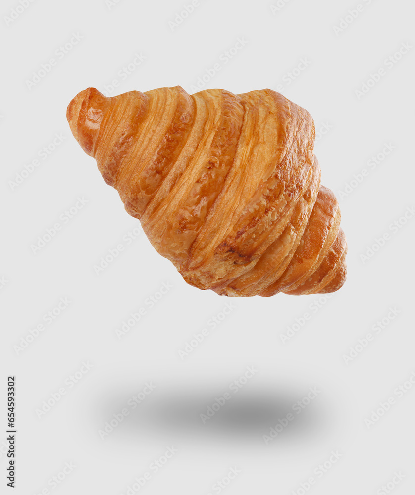 Freshly baked croissant in air on light grey background Freshly baked croissant in air on light grey background