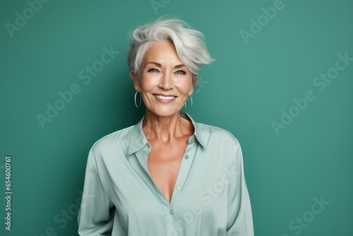 Mature woman winks playfully, her joy captured against a refreshing spearmint green. Enhanced by innovative generative AI for a contemporary touch.