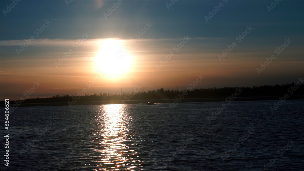 Dawn with a beautiful sky. Clip. Bright glowing sun awakened over the river surrounded by forests.