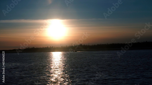 Dawn with a beautiful sky. Clip. Bright glowing sun awakened over the river surrounded by forests. © Media Whale Stock