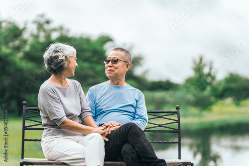 Asian people mature husband and wife, seated on chairs, elderly couple, seated in the park on comfortable chair, deep love and lifelong. Elderly Love Senior Couples, long life togetherness © M+Isolation+Photo