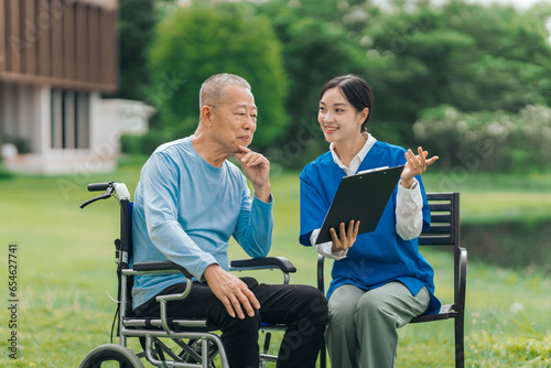 Asian people elderly man on wheelchair with caregiver nurse outdoor, , exemplifying the essence of holistic well-being and compassionate support. Nature Therapy © M+Isolation+Photo
