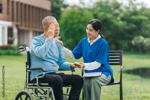 Asian people elderly man on wheelchair with caregiver nurse outdoor, , exemplifying the essence of holistic well-being and compassionate support. Nature Therapy © M+Isolation+Photo