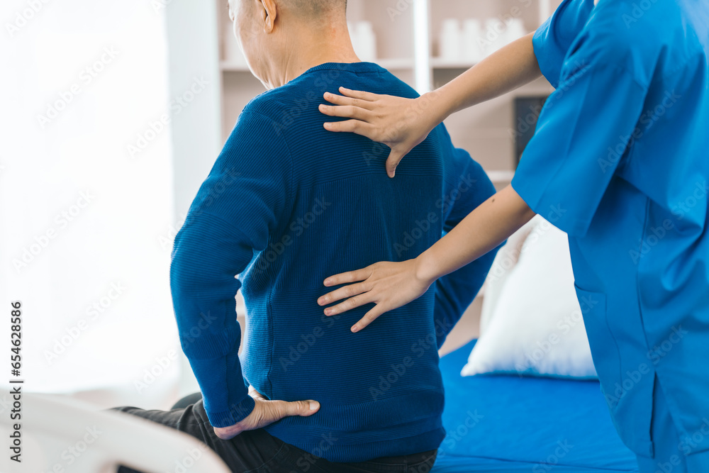 Asian people caregiver provides gentle support and encouragement to an elderly man during physical therapy session in a nursing care facility, promoting strength, mobility, and well-being.