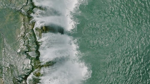 Slow motion top view of water flowing down to people on bamboo raft. Tinuy an falls in Mindanao, Philippines. photo