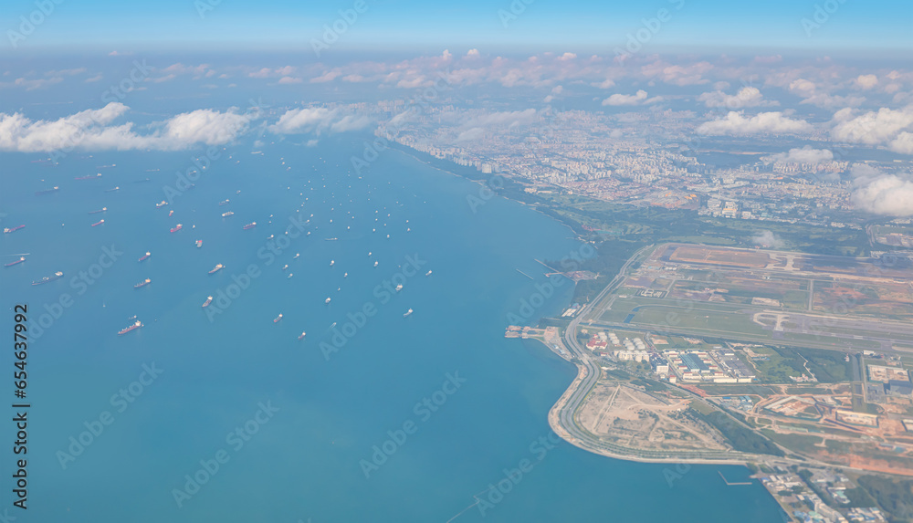 Aerial view of Singapore Changi Airport - Commercial Tankers and container ships wait in the Straits of Singapore