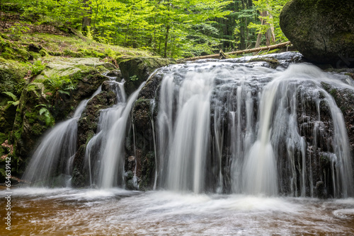 Long exposure of stream waterfalls in summer forest