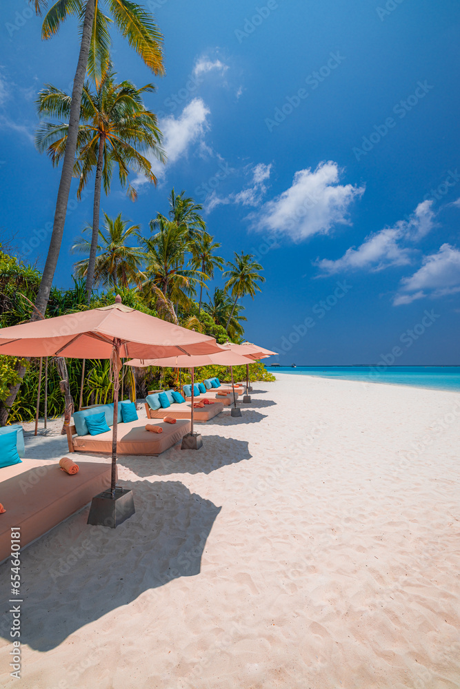 Popular summer holiday and vacation destination. Sunny sea coast umbrellas chairs beach beds coconut palm trees. Luxury travel, best landscape. Tropical paradise island. Exotic seaside calm wellbeing