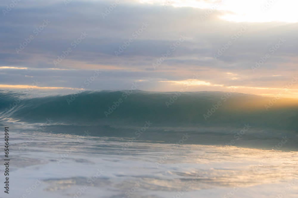 A wall of wave and cloudy sky.