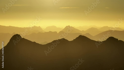 Cinematic aerial view of a mountain range on a beautiful orange sunset in the Pyrenees
