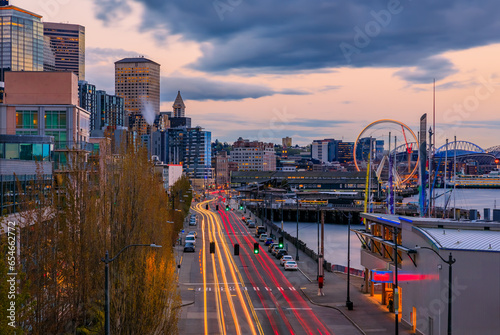 Seattle waterfront skyline with a view over the Great Wheel, the Puget Sound, and traffic light trails at sunset in Seattle, Washington, USA
