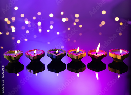 Close up of six diwali candles with copy space on purple background