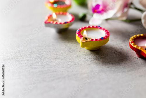Close up of diwali candles and flowers with copy space on grey background