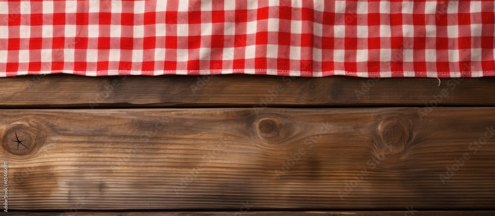 Red patterned picnic tablecloth on wood background