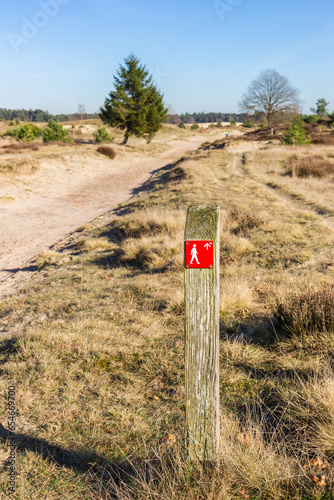 Red sign pointing to the walking direction in Drents Friese Wold National Park, Netherlands photo