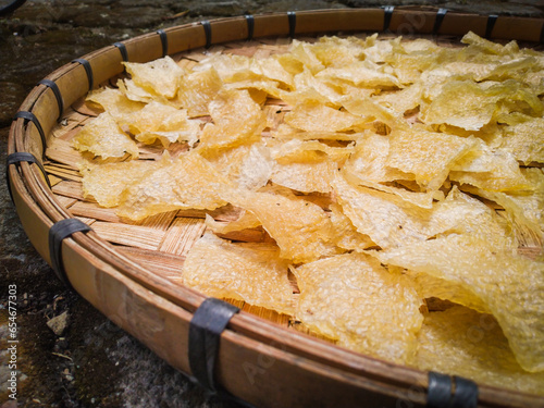 Kerupuk Nasi, Kerupuk Gendar or Rice Crackers, before fried. Indoneisian traditional food on a woven bamboo tray. Close up photo