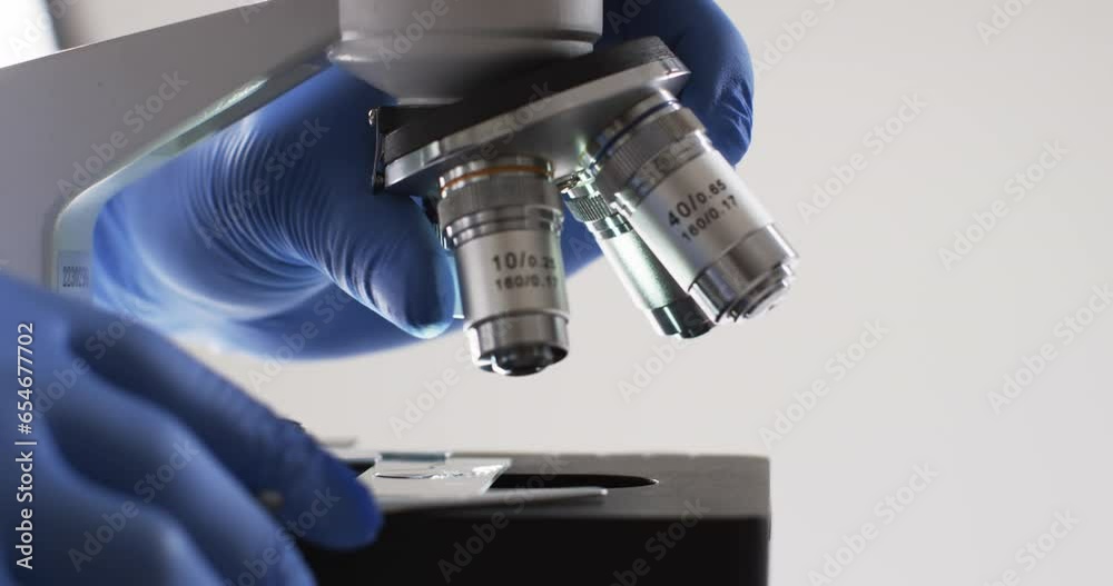 Video of close up of scientist using laboratory microscope with copy space on white background Video of close up of scientist using laboratory microscope with copy space on white background