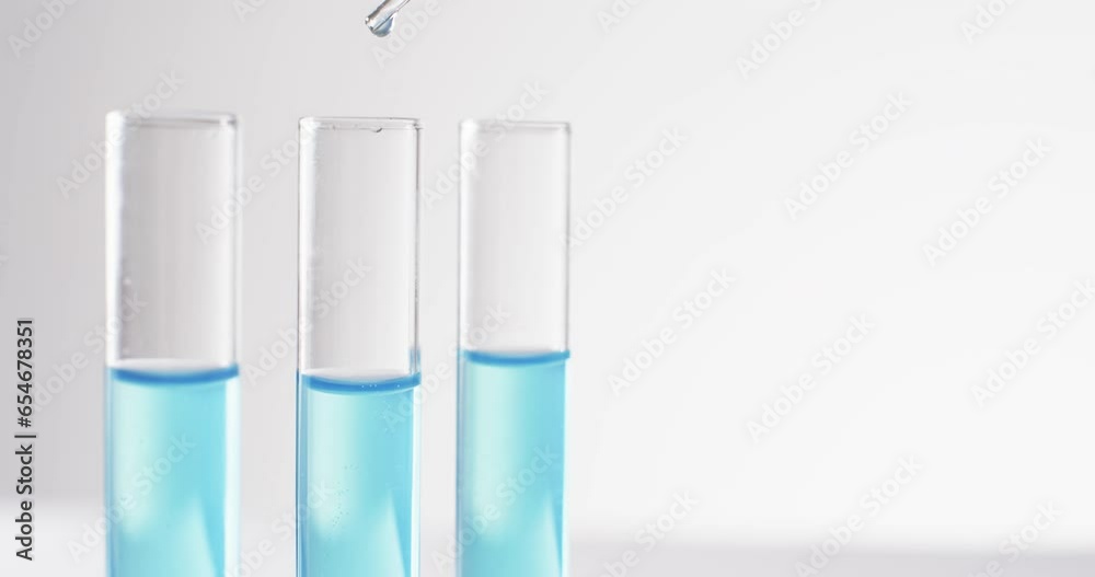 Video of glass laboratory test tubes and pipette with blue liquid and copy space on white background Video of glass laboratory test tubes and pipette with blue liquid and copy space on white background