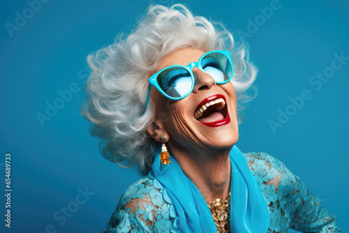 cheerful and funny happy old woman in vivid shine blue background