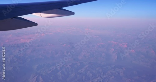 An airplane wing seen through an oval window. View on a North Pole.