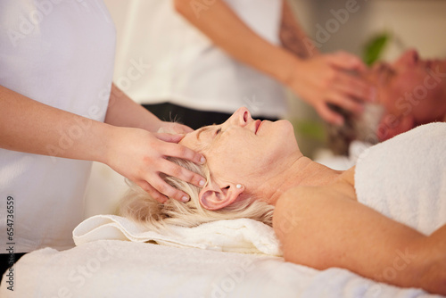 Relax, head massage and senior couple at a spa for health, wellness and anti aging skincare treatment. Calm, beauty and elderly man and woman in retirement with wrinkles face routine at natural salon