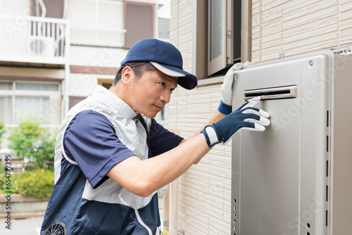 給湯器の点検をする作業員の男性 photo