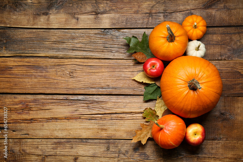 Thanksgiving day. Flat lay composition with pumpkins on wooden table, space for text