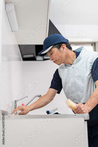 シンクを掃除する作業員の男性