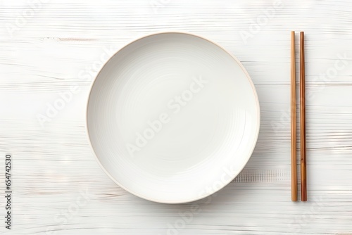 Ceramic plate and chopsticks on white table