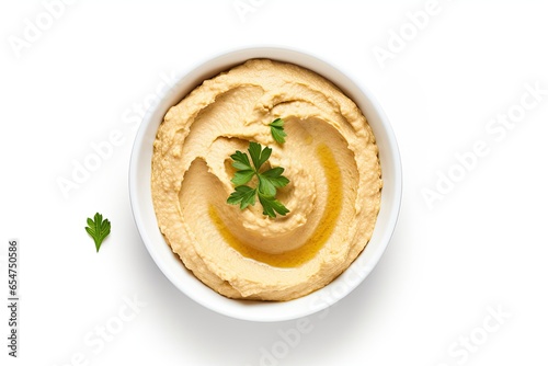 Top down view of homemade hummus in a white bowl isolated