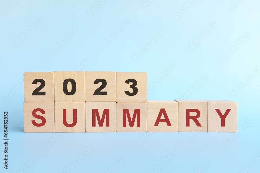 Year 2023 review and summary concept. Wooden blocks typography in blue background. - obrazy, fototapety, plakaty 