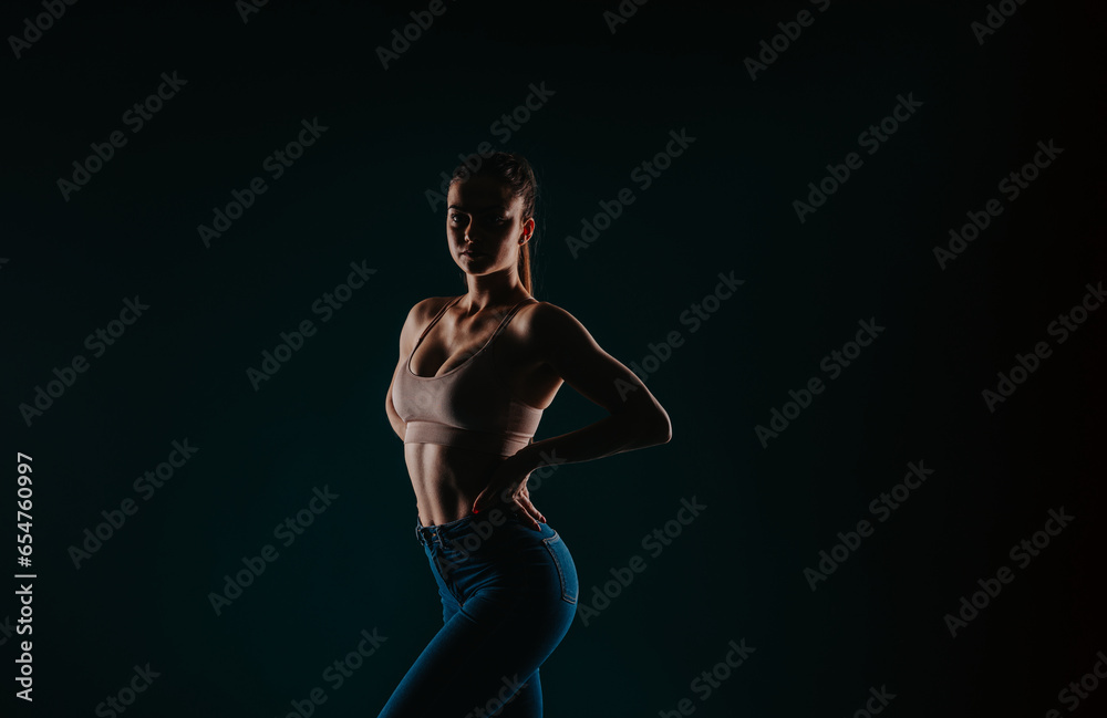 Confident fit woman, muscular arms. Studio shot on black background. Results of body transformation, motivation, progress. Confident fit woman, muscular arms. Studio shot on black background. Results of body transformation, motivation, progress.