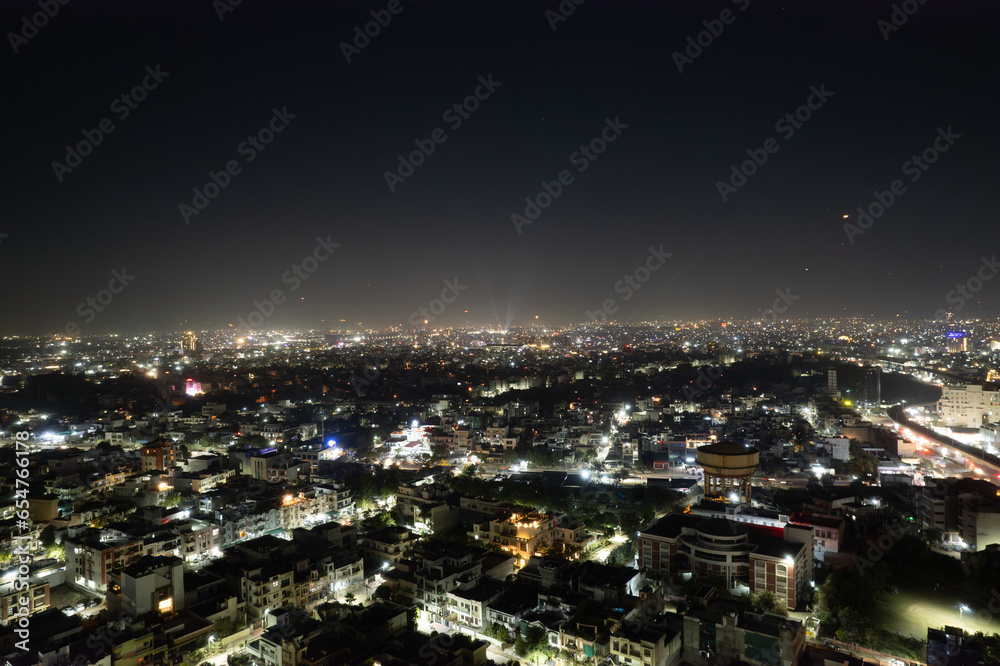 aerial drone tripod shot showing cityscape of jaipur delhi with fireworks, rockets, pyrotechnics and sky lanterns at night in celebration of makar sankranti, independence republic day and diwali in In