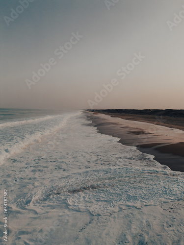 Sunrise at Ondres beach in France between waves and sand seen from drone © Neos