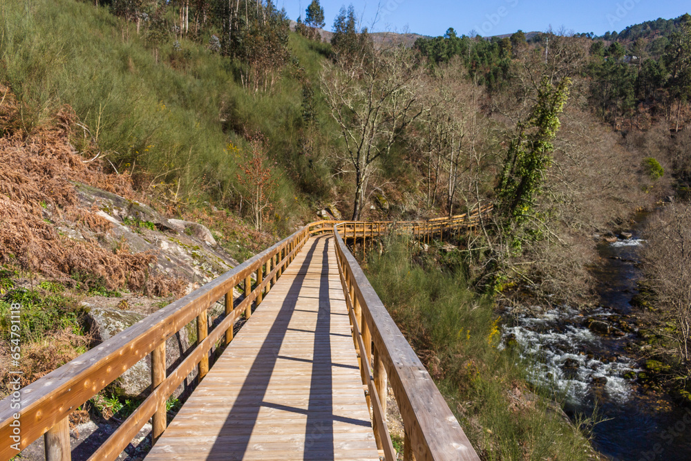The river hiking trail Ecovia do Vez near Arcos de Valdevez, Portugal. Ecovia do Vez wooden pathways along the riverside. The river hiking trail Ecovia do Vez near Arcos de Valdevez, Portugal. Ecovia do Vez wooden pathways along the riverside.
