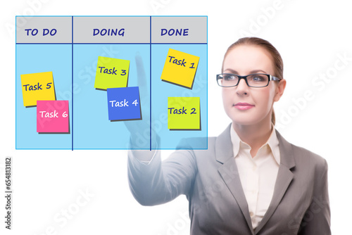 Businesswoman working on kanban board with tasks photo