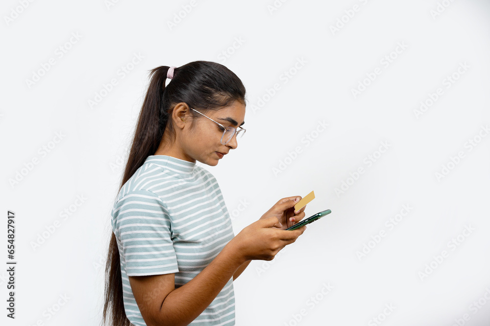 Beautiful young blonde woman holding up a credit card while avoiding her eyes from the copy space in the picture pose. Beautiful young blonde woman holding up a credit card while avoiding her eyes from the copy space in the picture pose.