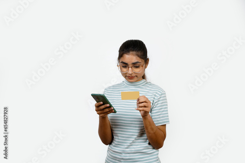 Beautiful young blonde woman holding up a credit card while avoiding her eyes from the copy space in the picture pose.