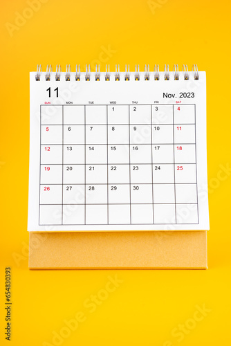 The November 2023, Monthly desk calendar for 2023 year on yellow color background.