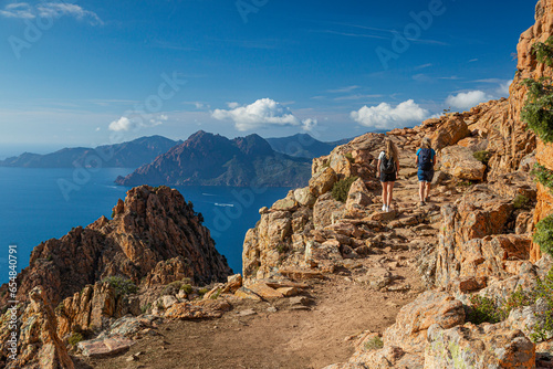 Fotografie zwei  Wanderer laufen in der Calanche einer bizarre Felsenlandschaft an der Sued