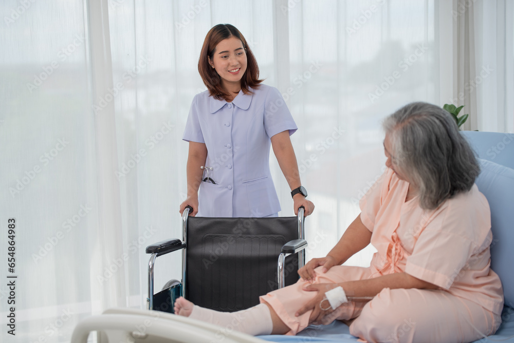 Obraz premium Asian nurse preparing wheelchair for senior female patient at the hospital ward