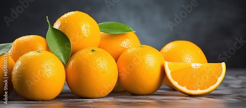 Sliced and whole ripe oranges on dark background
