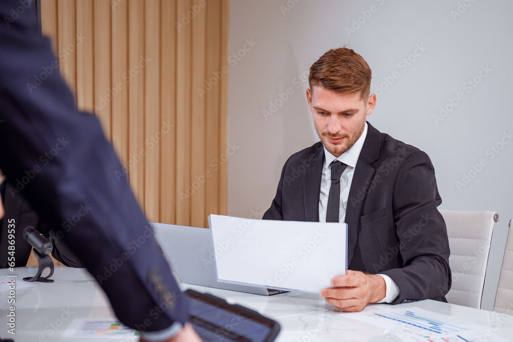 Portrait of Caucasian male businessman Sitting in the office reading meeting documents. Portrait of Caucasian male businessman Sitting in the office reading meeting documents.