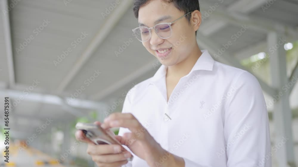 Emotional man uses phone under office building Emotional man uses phone under office building