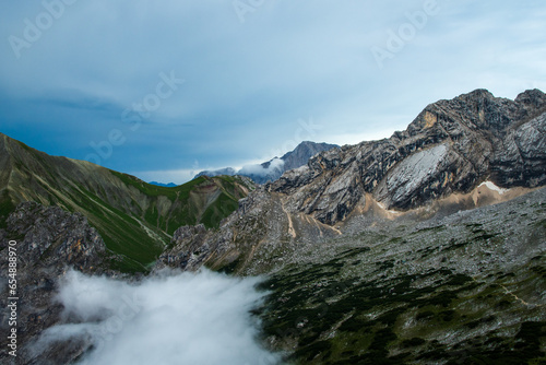 rising clouds in the valley with a panoramic view on the peaks of Gatterlkopf, Hochwand and Karkopf in the Wetterstein Mountains of the Alps
